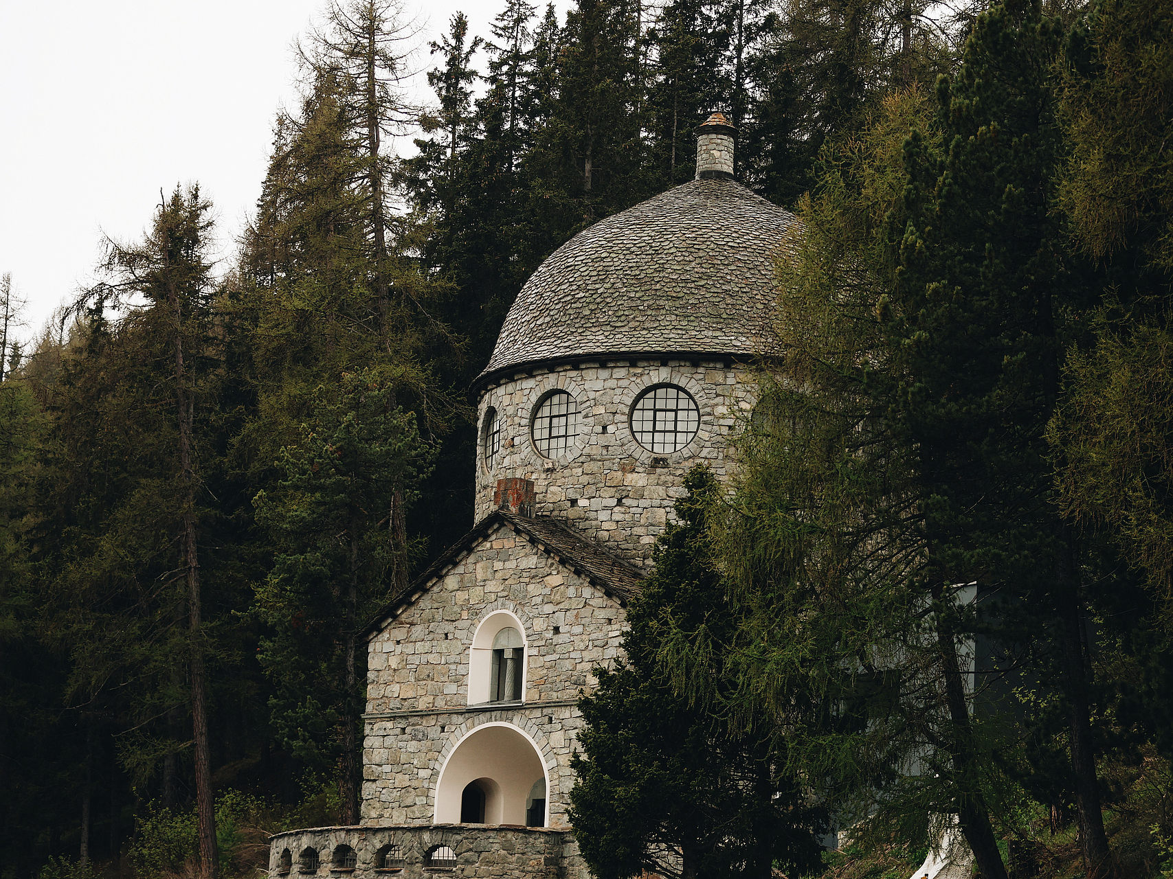 Steinkirche im Wald Steinkirche mit runder Kuppel und Bogenportal umgeben von Nadelbäumen