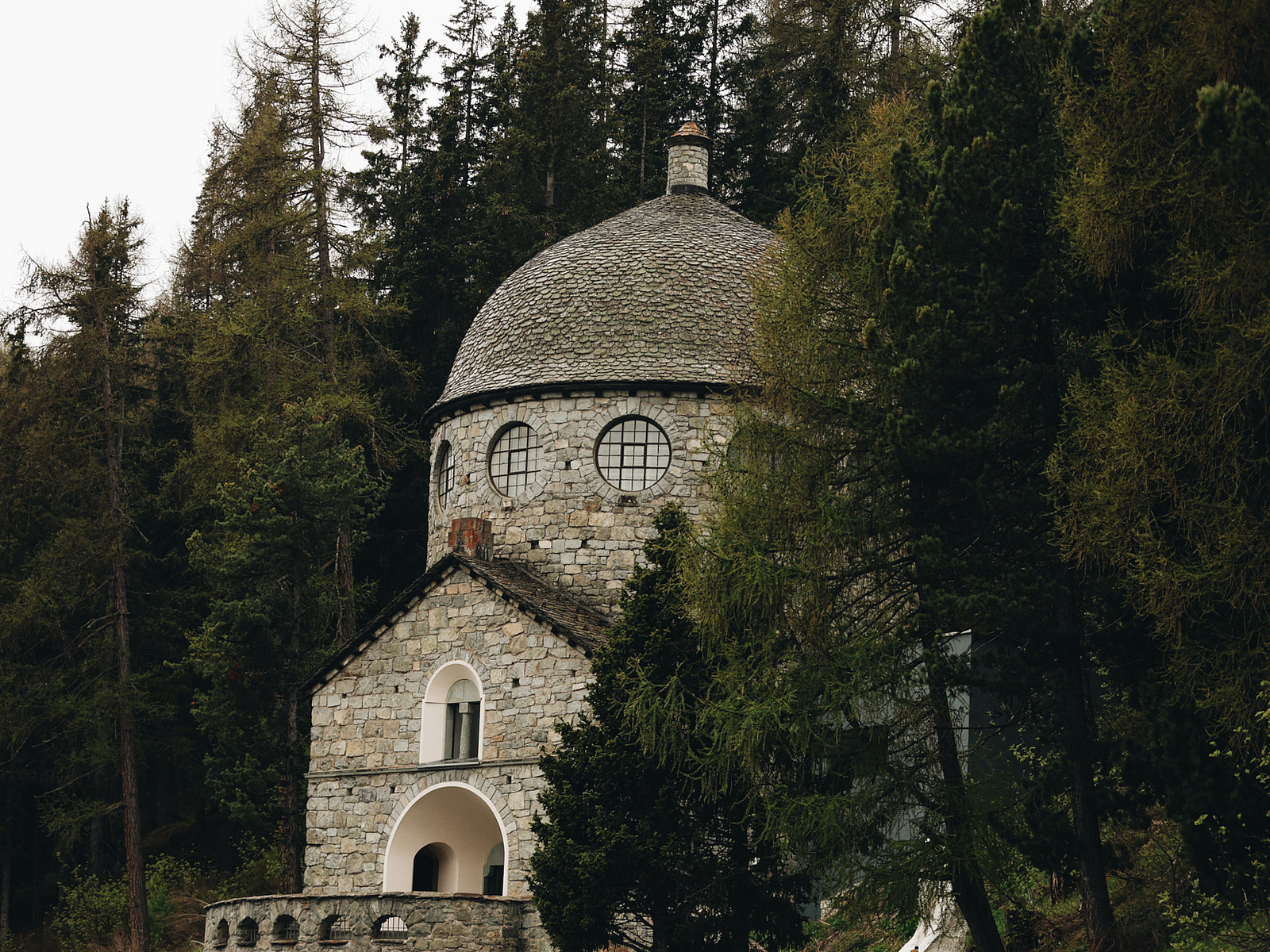 Steinkirche im Wald Steinkirche mit runder Kuppel und Bogenportal umgeben von Nadelbäumen