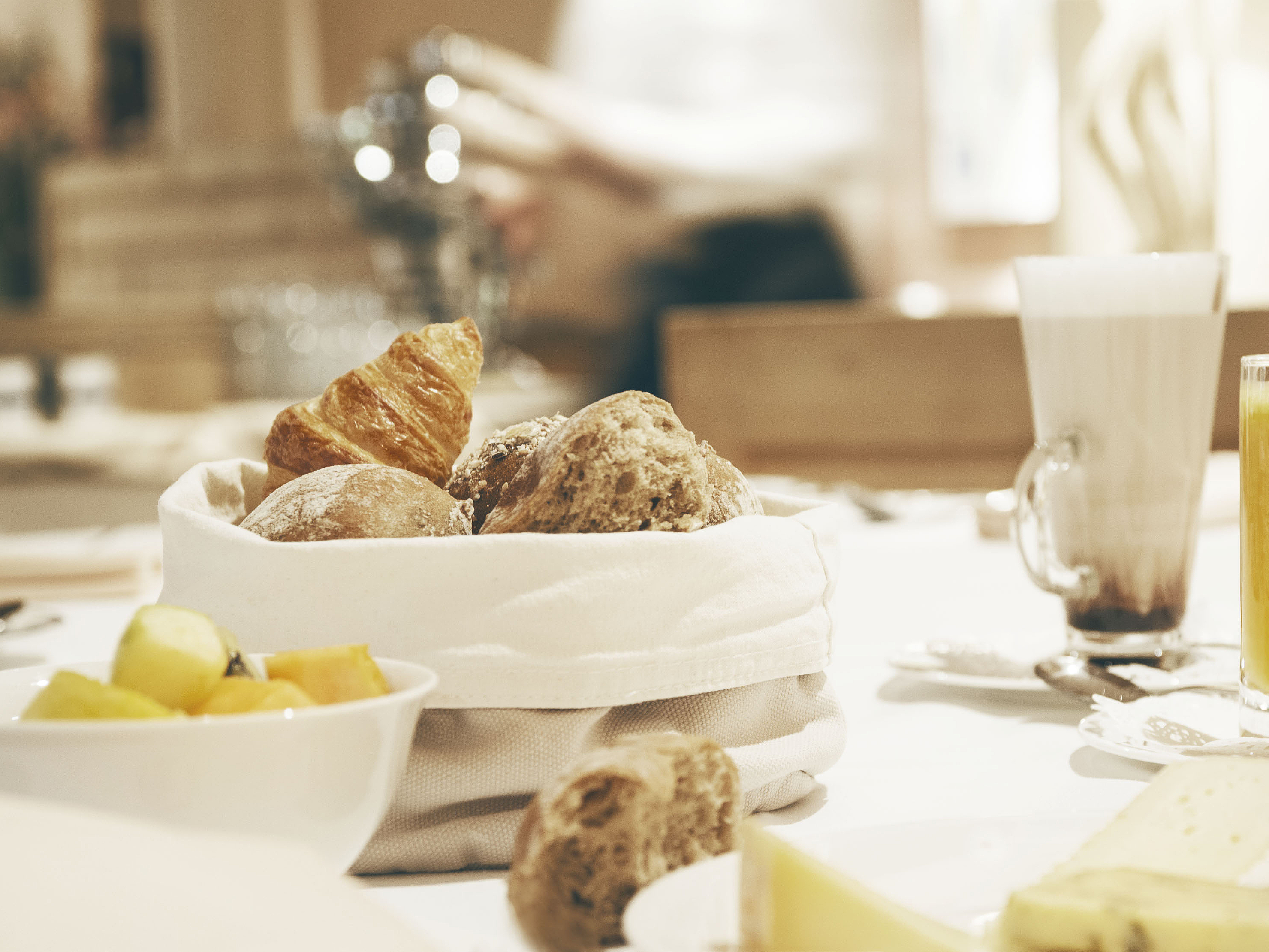 Frühstückstisch mit Brot und Saft Frühstückstisch mit Brotkorb, Orangensaft und Latte Macchiato.
