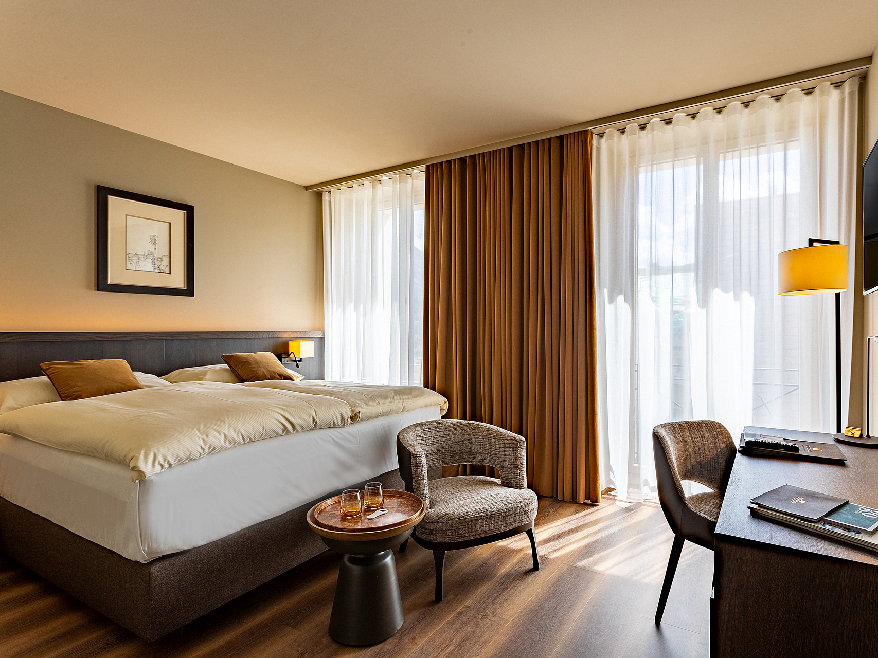 Modernes Hotelzimmer Modernes Hotelzimmer mit Bett, Schreibtisch, Sessel und Fenstern.