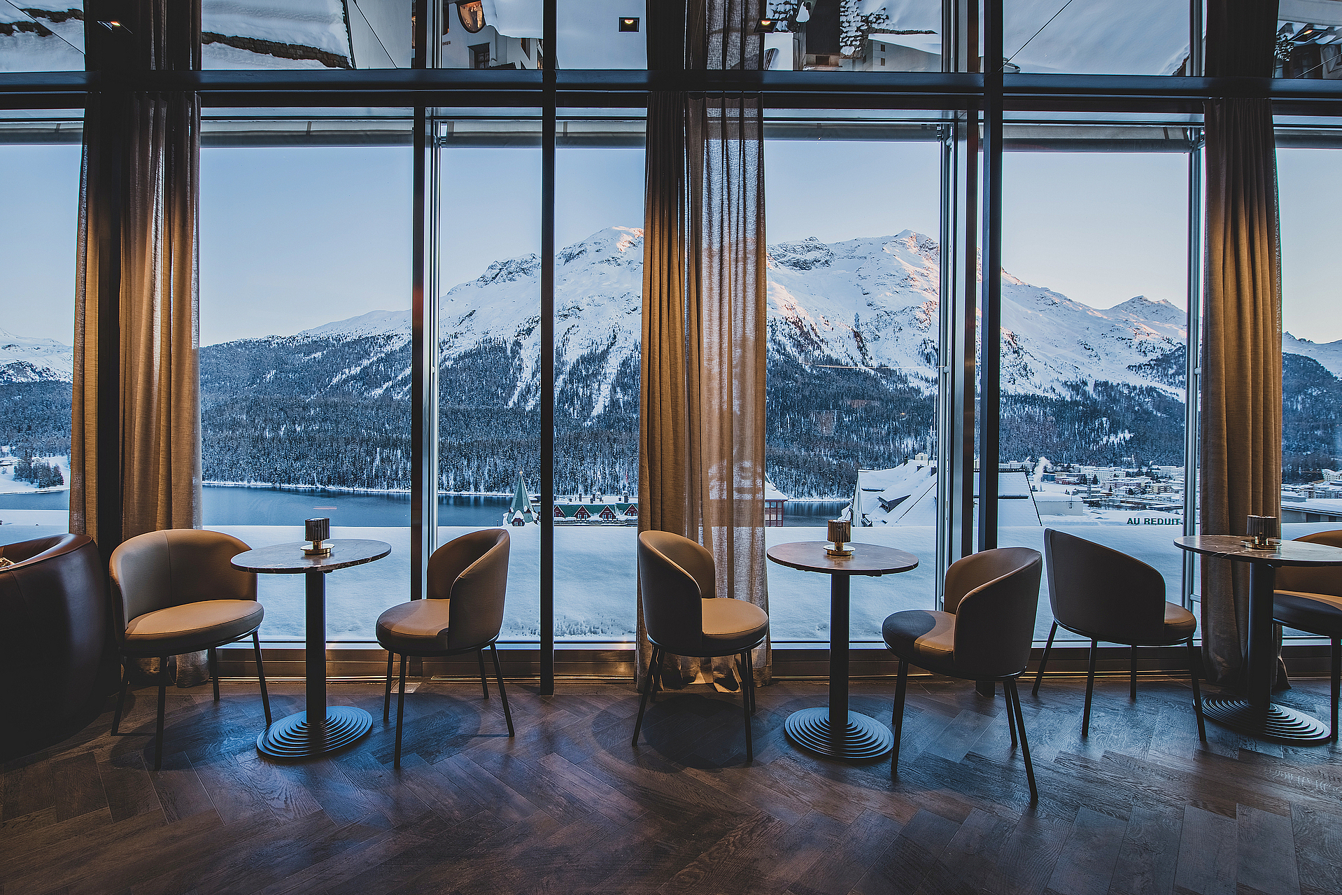 Alpenblick aus Luxus-Lounge Lounge mit großen Fenstern und Blick auf schneebedeckte Berge.