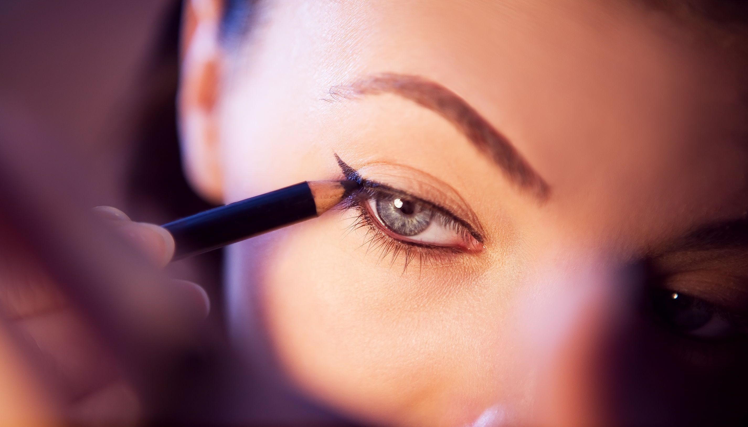 Eyeliner auftragen Nahaufnahme einer Frau, die Eyeliner mit einem Stift aufträgt