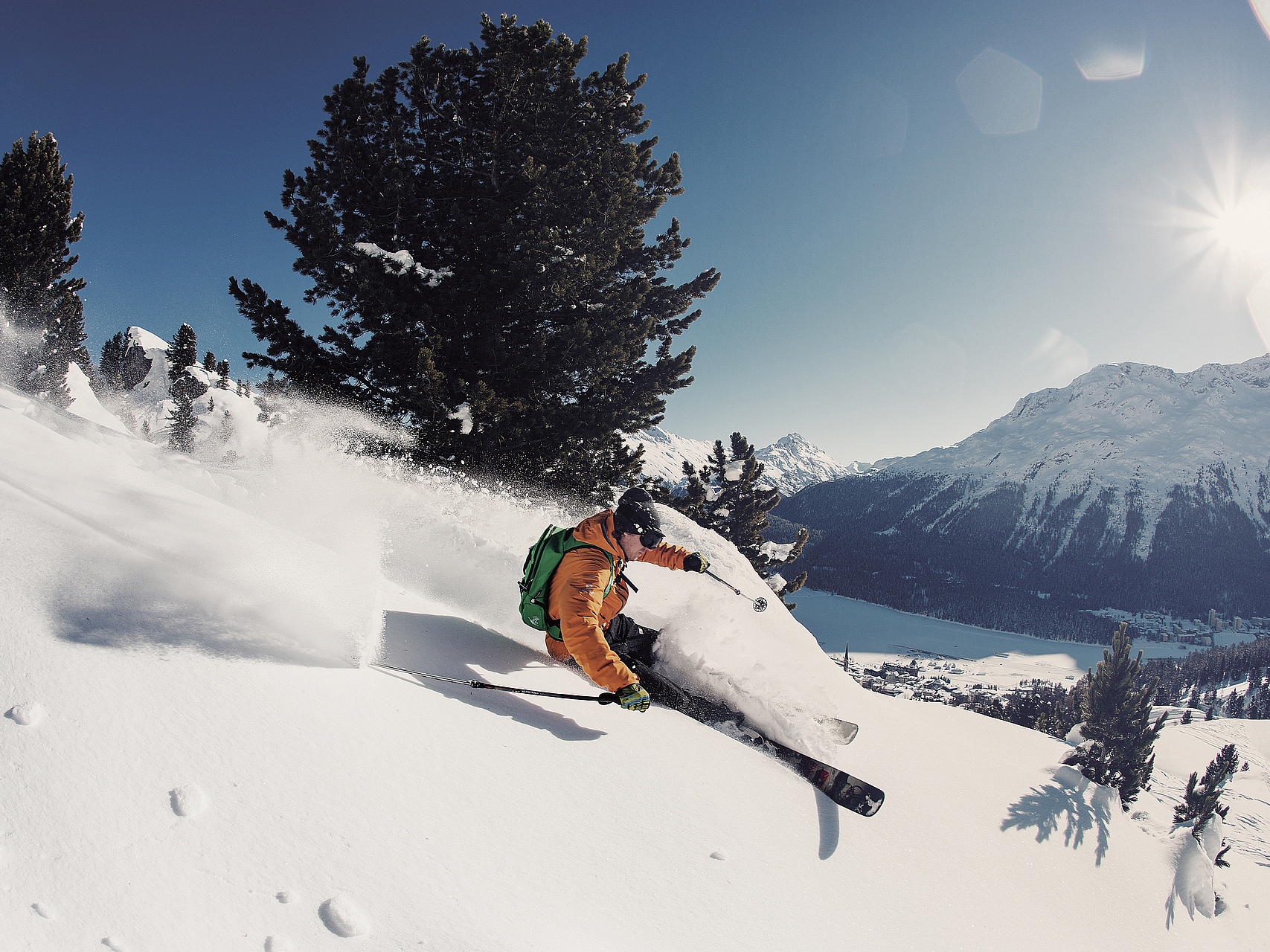 Skifahrer im Tiefschnee Skifahrer in orangefarbener Jacke beim Freeriden im Schnee