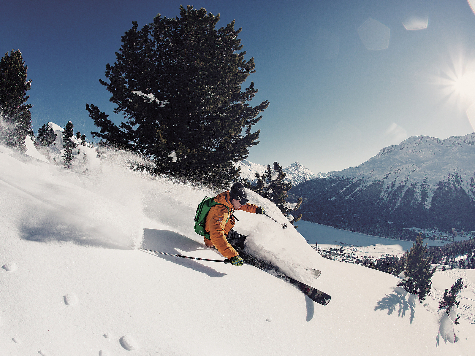 Skifahrer im Tiefschnee Skifahrer in orangefarbener Jacke beim Freeriden im Schnee
