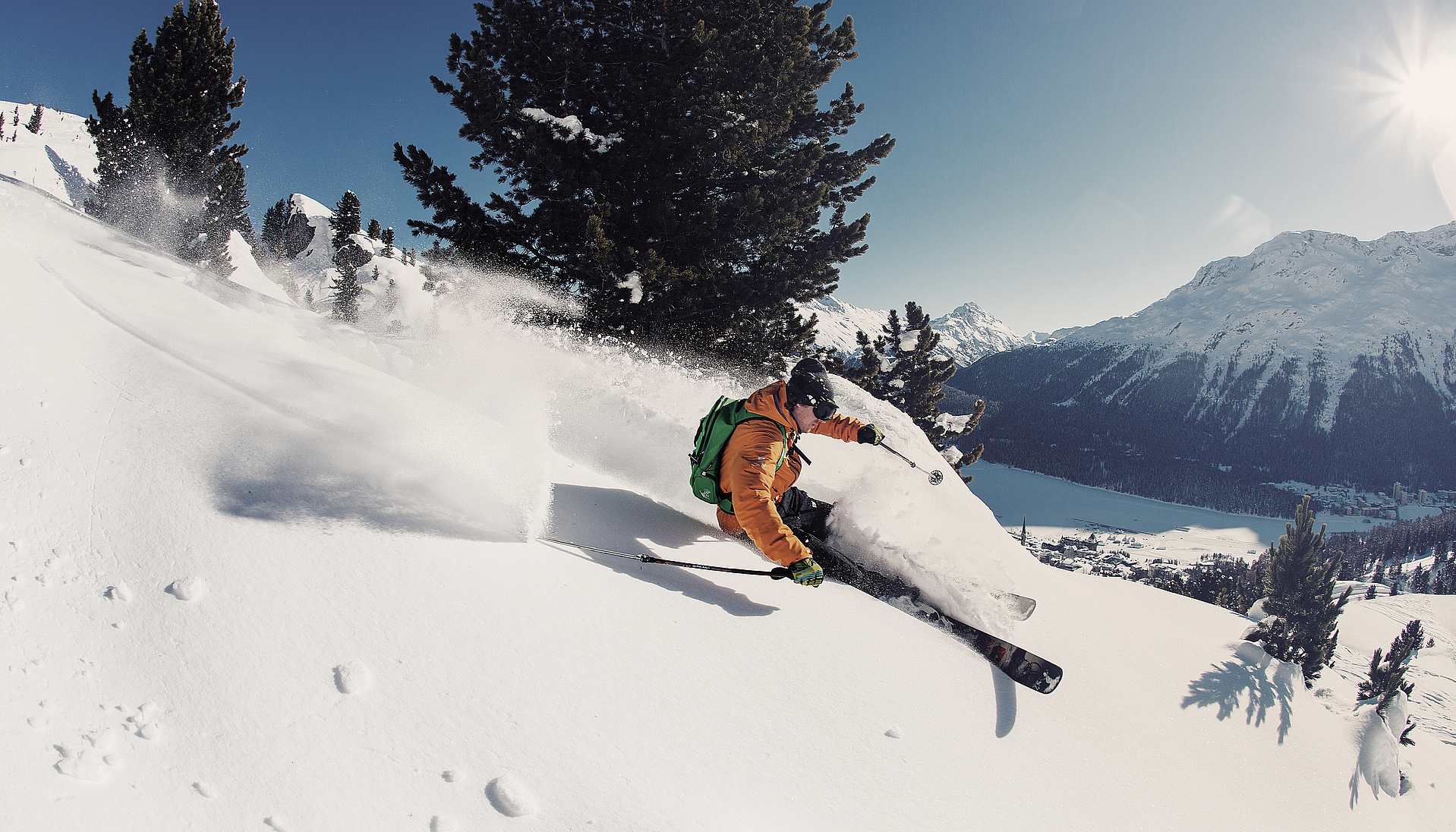 Skifahrer im Tiefschnee Skifahrer in orangefarbener Jacke beim Freeriden im Schnee