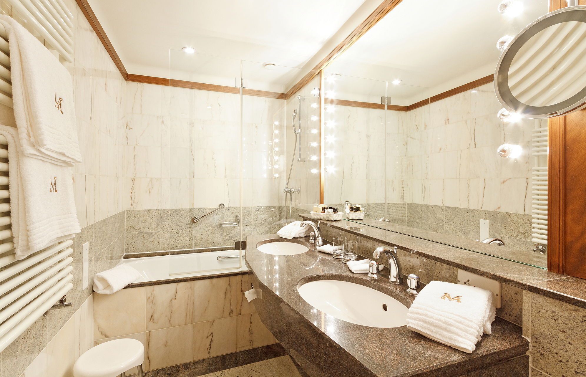Luxuriöses Hotelbadezimmer Elegantes Hotelbadezimmer mit Doppelwaschbecken, Badewanne und Marmor.