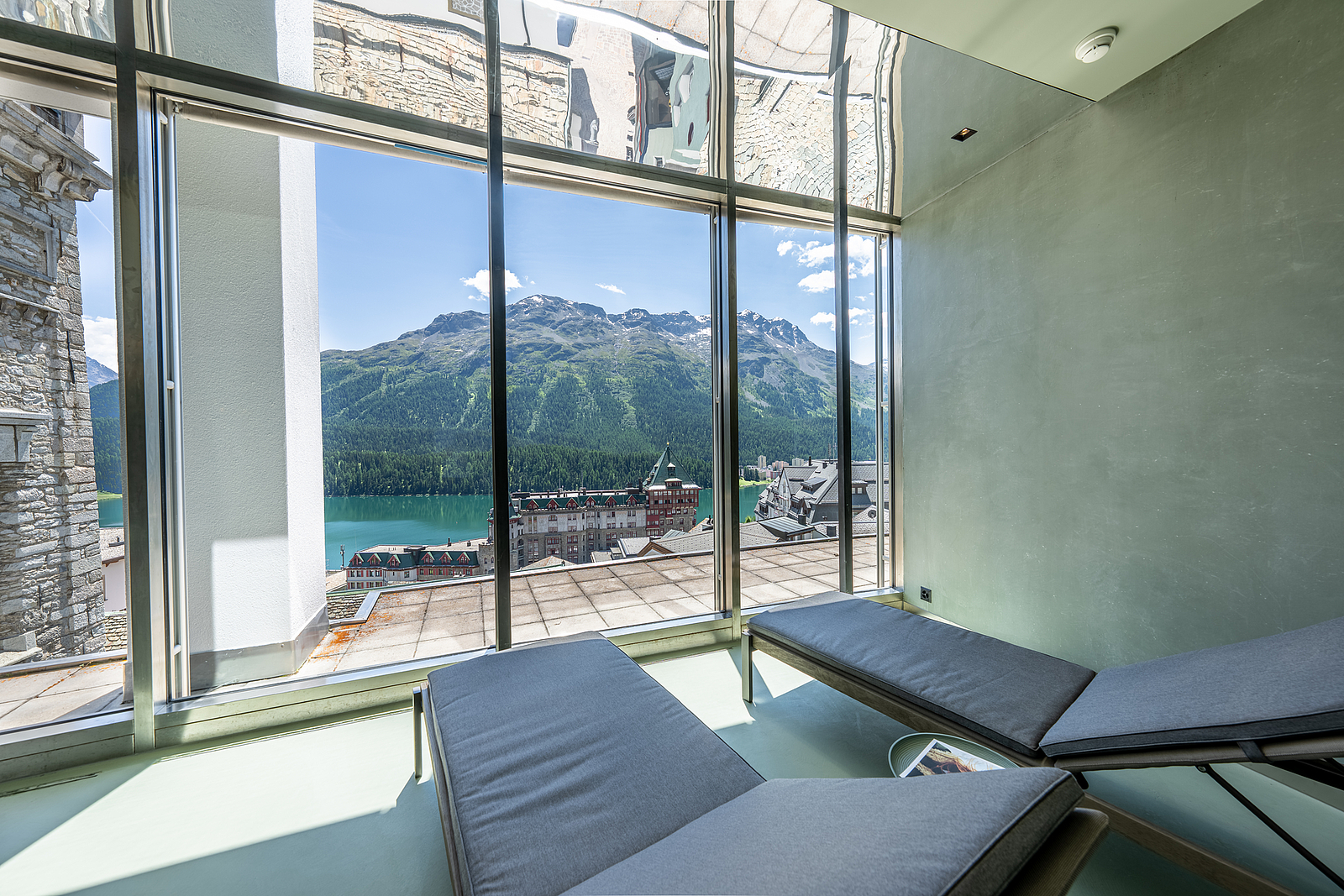 Ruheraum mit Berg- und See Blick Moderner Ruheraum mit Liegen und großen Fenstern mit Blick auf Berge und See.