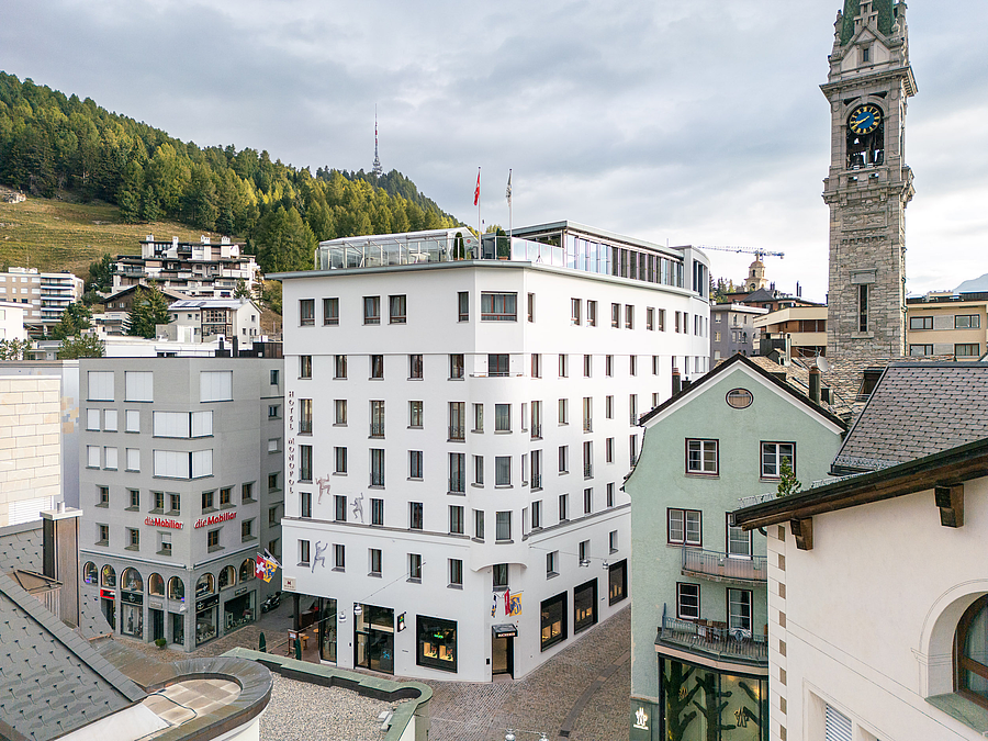 Luftaufnahme des Hotel Monopol und eines Steinturms in St. Moritz.