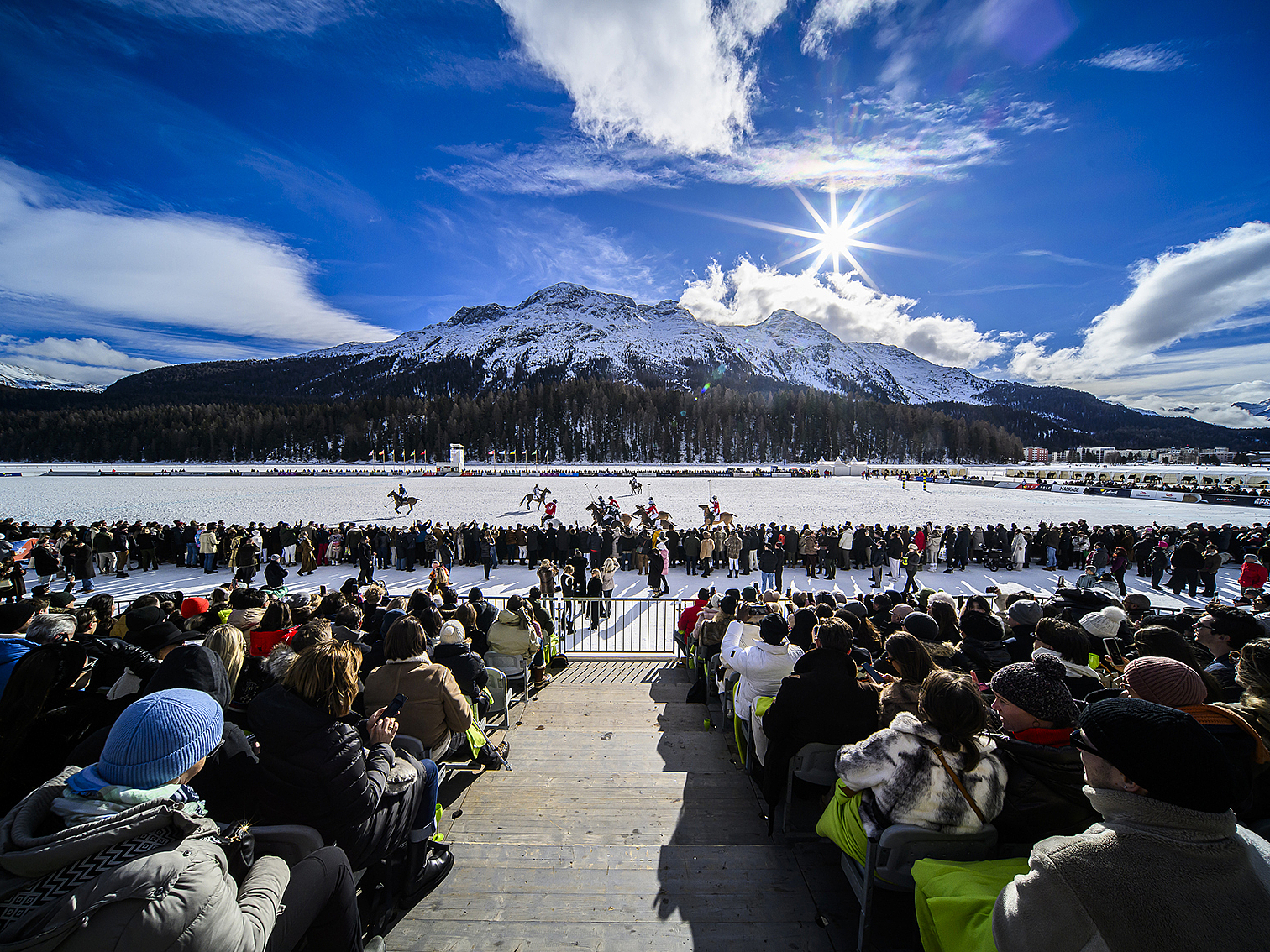 Snow-Polo-Turnier in St. Moritz Snow-Polo-Spiel auf einem gefrorenen See mit Zuschauern und schneebedeckten Bergen im Hintergrund.