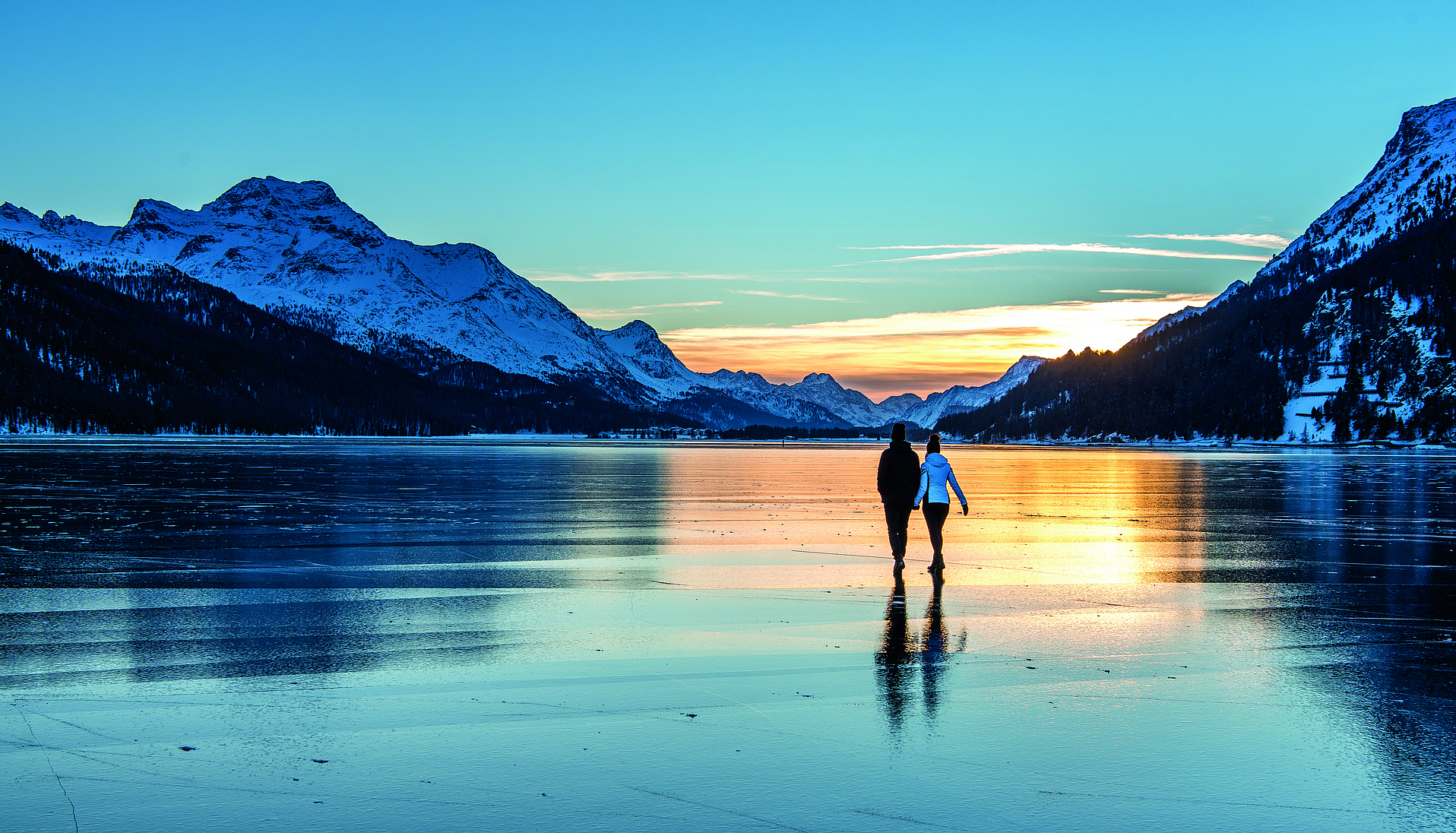 Winterspaziergang auf gefrorenem See Paar beim Spaziergang auf einem gefrorenem See im Sonnenuntergang.