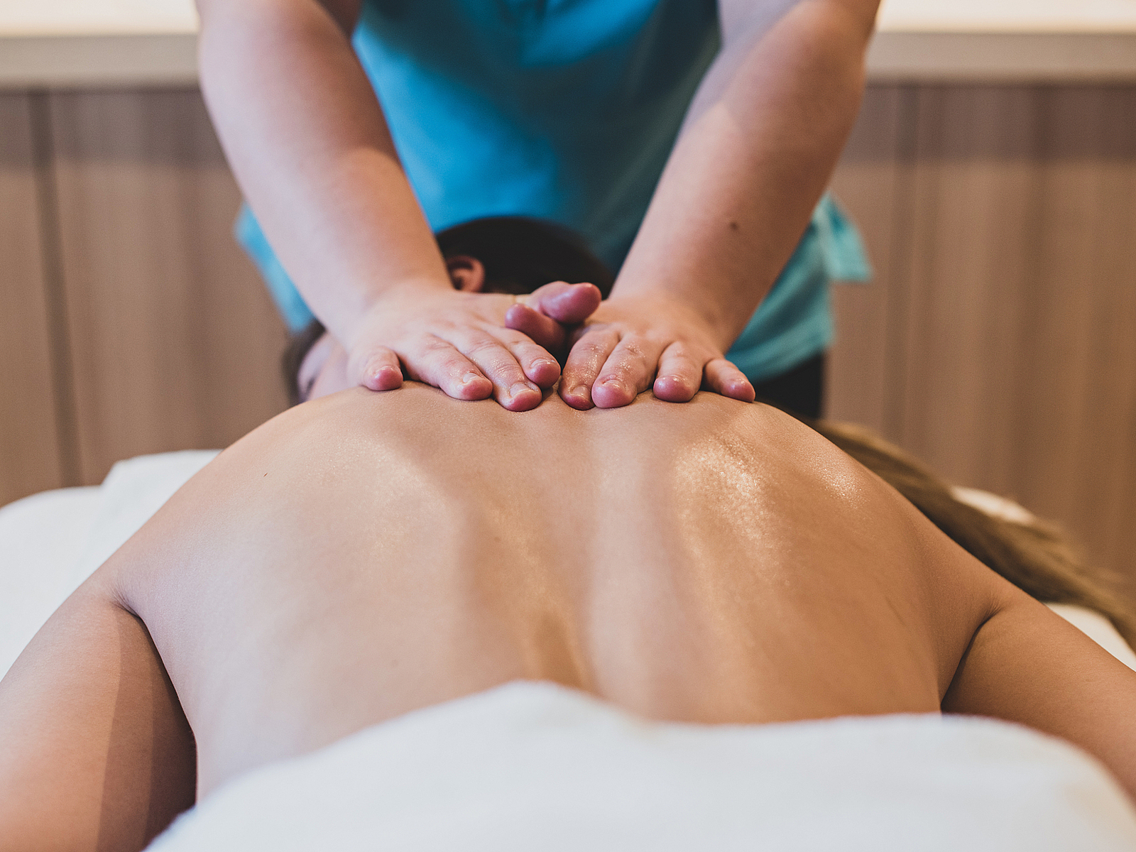 Entspannende Rückenmassage Masseurin gibt einer Person in einem Spa eine Rückenmassage.