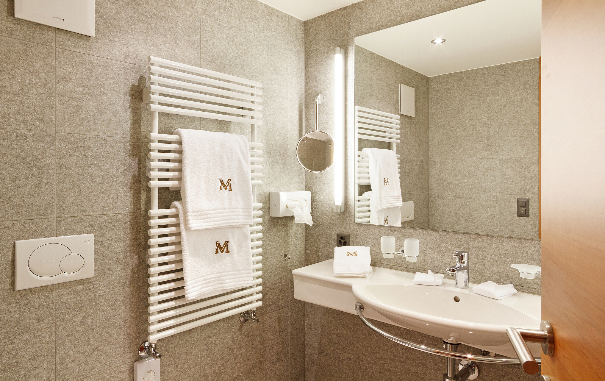 Modernes Hotelbadezimmer Modernes Hotelbadezimmer mit grauen Steinwänden und weißem Waschbecken