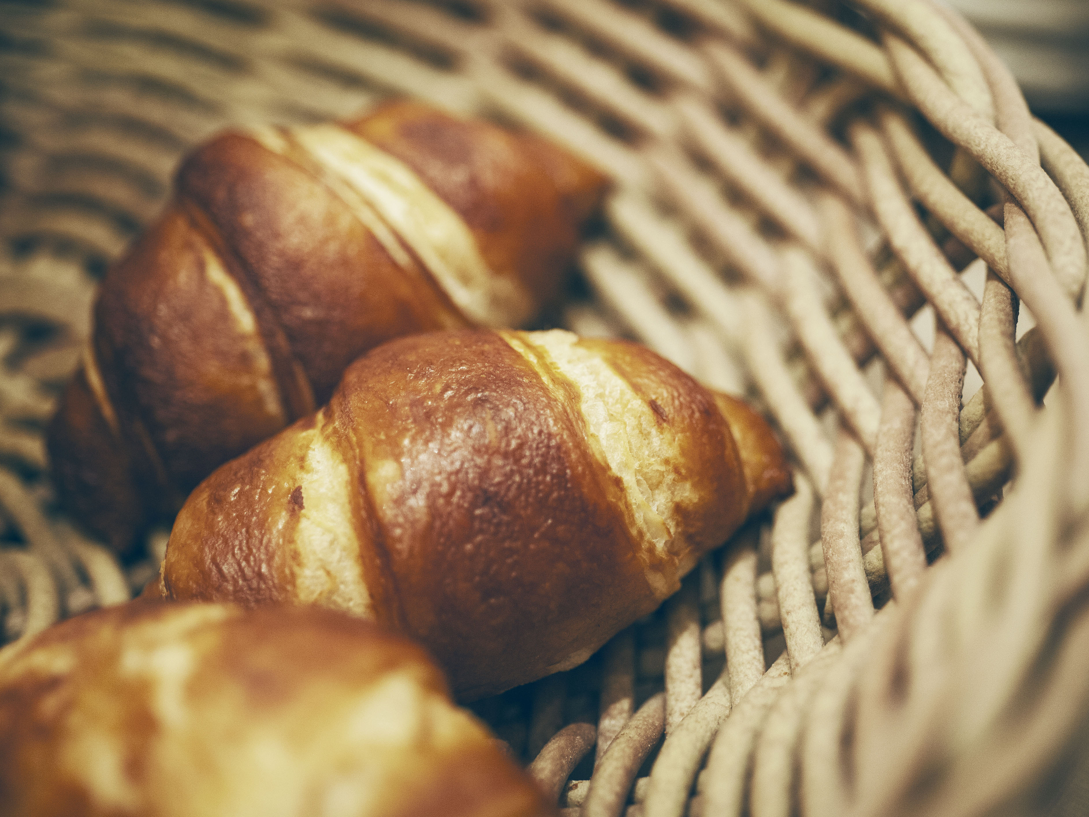 Laugen-Croissants im Korb Frische Laugen-Croissants in einem Weidenkorb