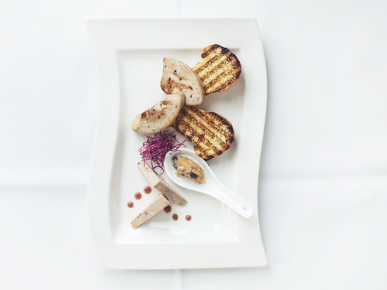 Gänseleber-Vorspeise mit Toast und Chutney auf Teller.