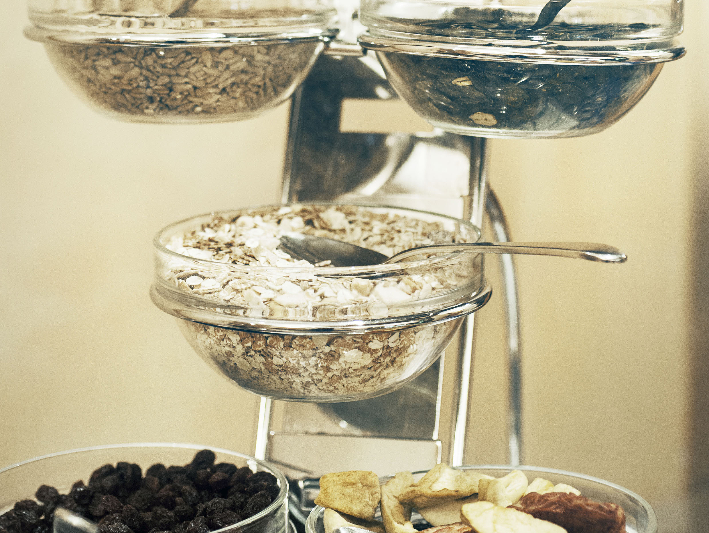 Müsli- und Getreideständer Glasschüsseln mit Müsli und Kernen auf einem Metallständer.