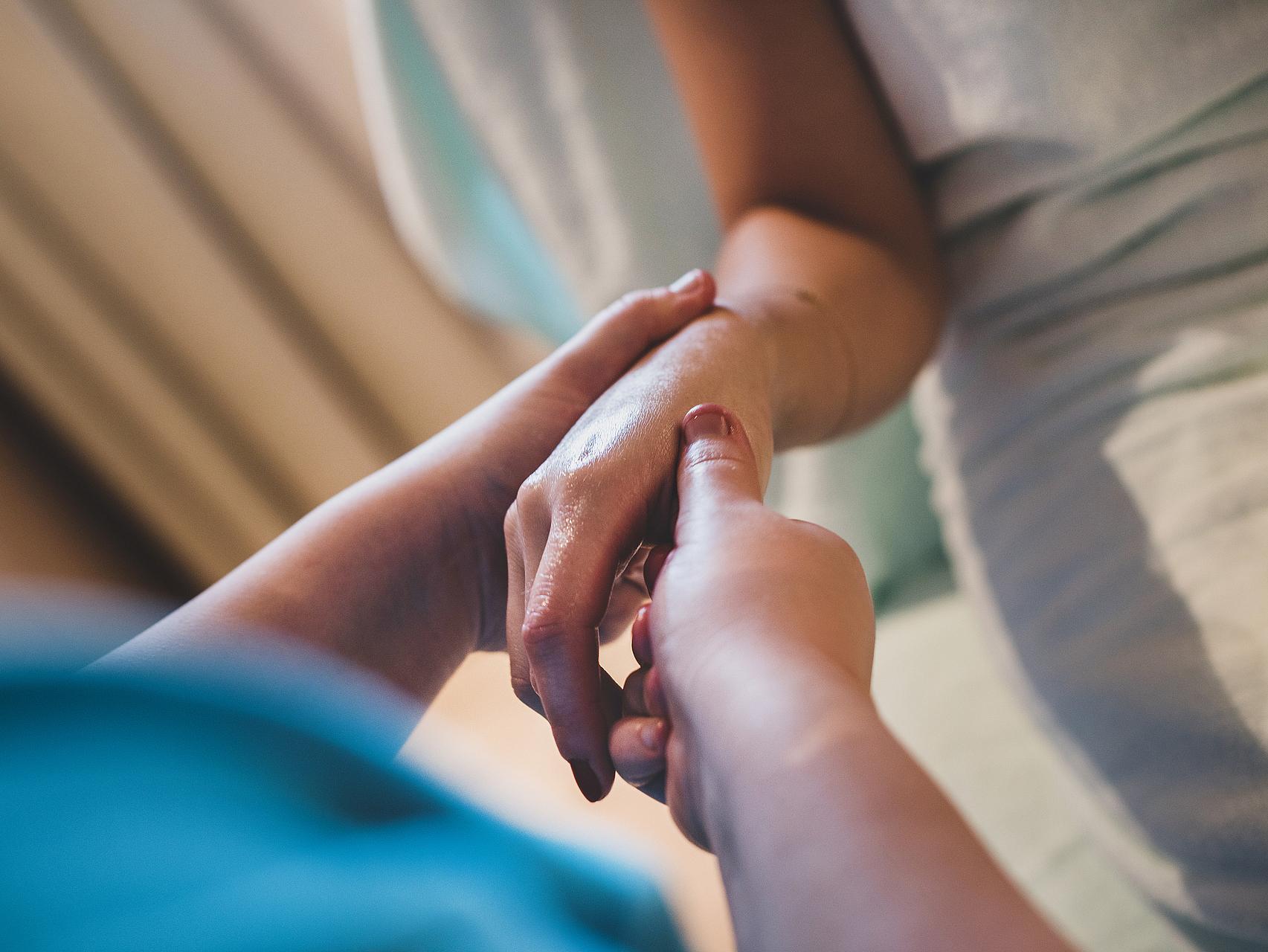 Medizinische Fürsorge Eine Pflegekraft hält einfühlsam die Hand eines Patienten.