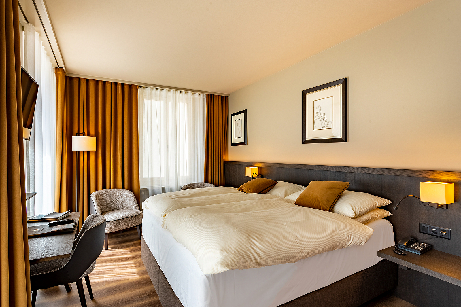 Gemütliches Hotelzimmer Modernes Hotelzimmer mit komfortablem Doppelbett, warmer Beleuchtung und Schreibtisch.