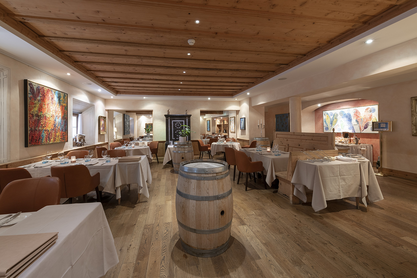 Gemütliches Restaurant Gemütliches Restaurant mit Holzbedeckung, gedeckten Tischen und orangefarbenen Stühlen.