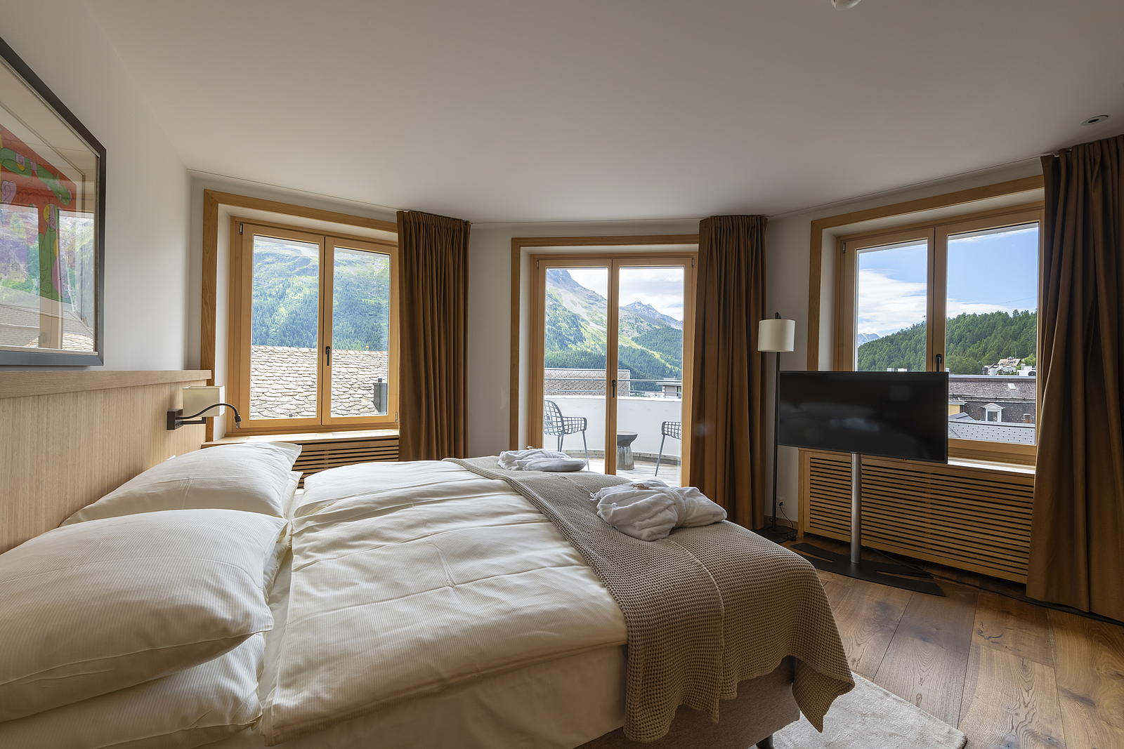 Hotelzimmer mit Bergblick Helliges Hotelzimmer mit großem Bett, Fenstern und Bergblick.
