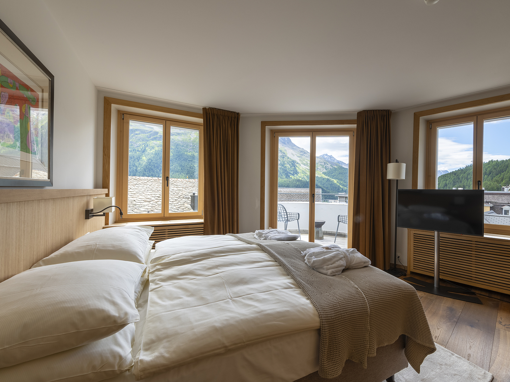 Hotelzimmer mit Bergblick Helliges Hotelzimmer mit großem Bett, Fenstern und Bergblick.