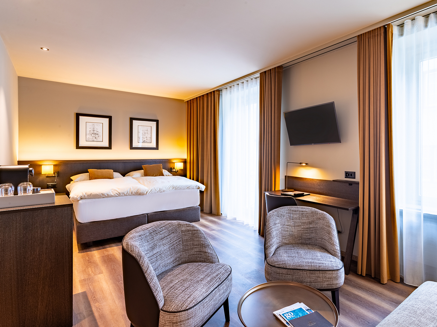 Modernes Hotelzimmer Modernes Hotelzimmer mit Bett, Sesseln, Schreibtisch und großen Fenstern.