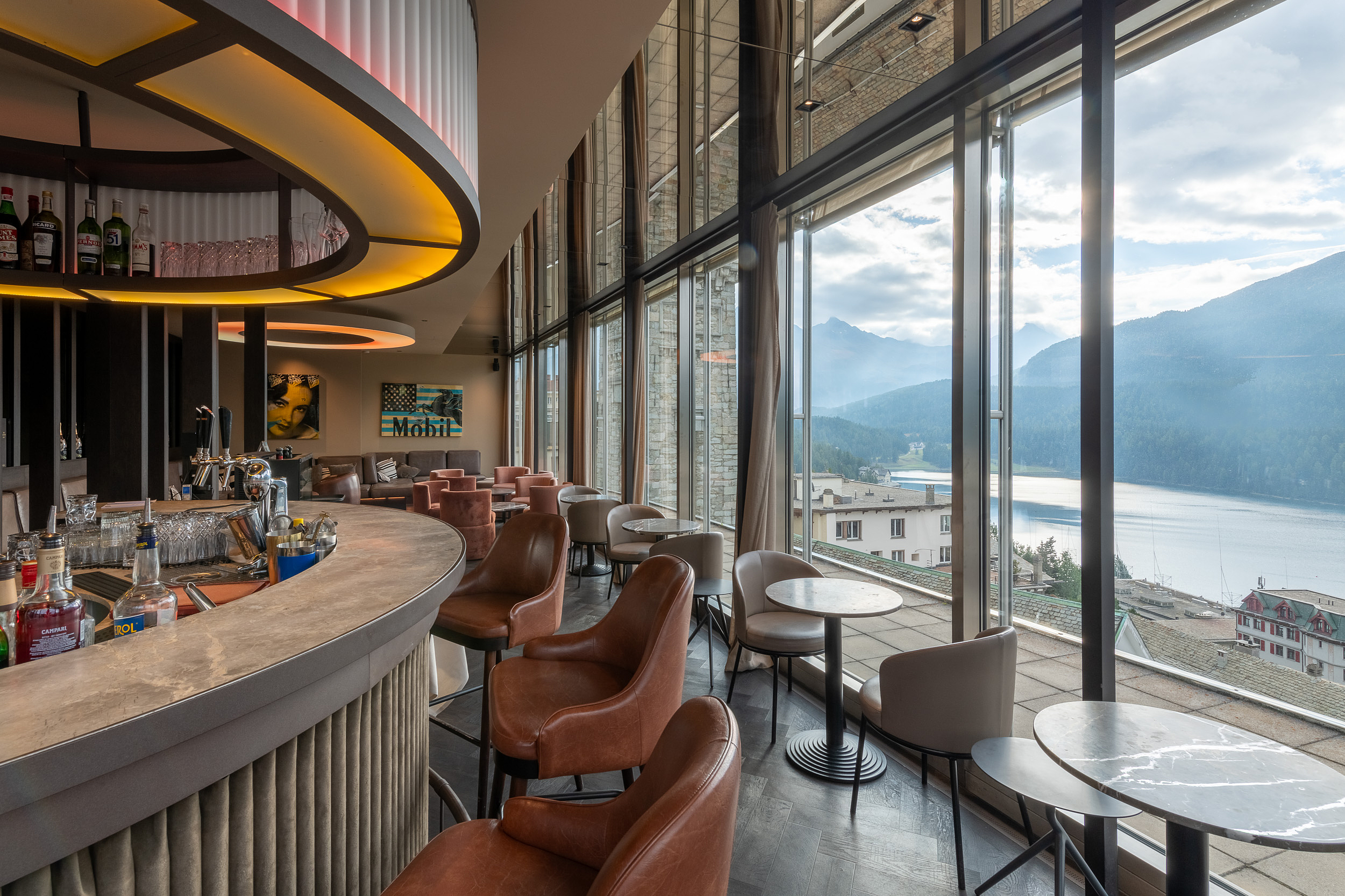 Moderne Bar mit Bergblick Moderne Bar mit Ledersesseln und großen Fenstern mit Blick auf einen Bergsee