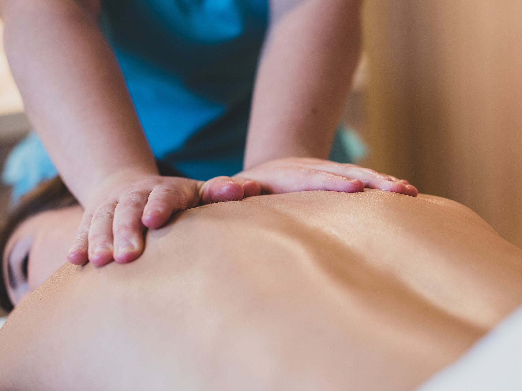 Entspannende Rückenmassage Nahaufnahme von Händen bei einer Rückenmassage.